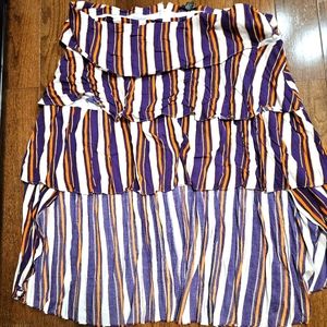 Purple and orange high low skirt with matching purple dress shirt.